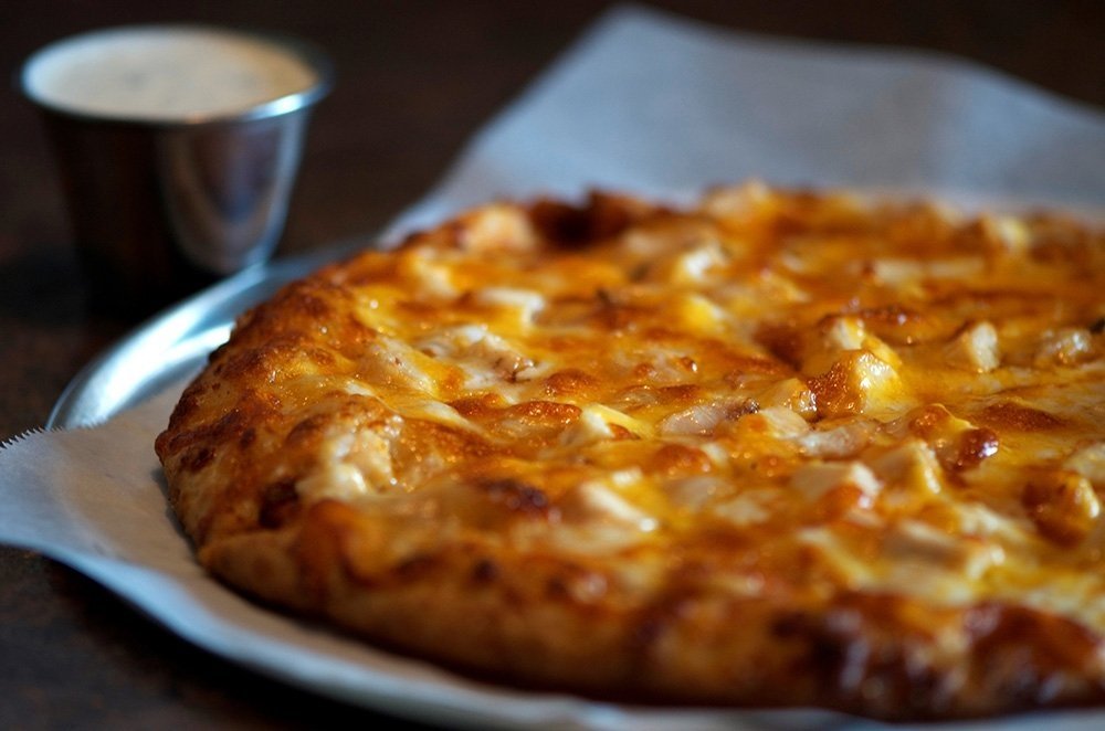 Buffalo chicken pizza with a cup of ranch